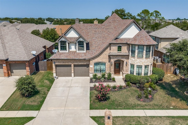 8521 Bonanza St, Aubrey, TX 76227 - view of front of house with driveway, a chimney, brick siding, and an attached garage