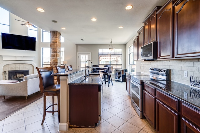 kitchen featuring appliances with stainless steel finishes, a breakfast bar, plenty of natural light, and ceiling fan