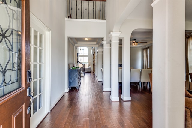 entrance foyer featuring dark wood-type flooring, decorative columns, and ceiling fan