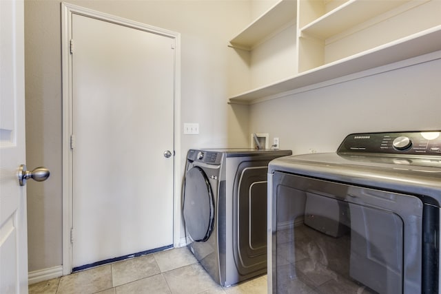 laundry room with washer and clothes dryer and light tile patterned floors