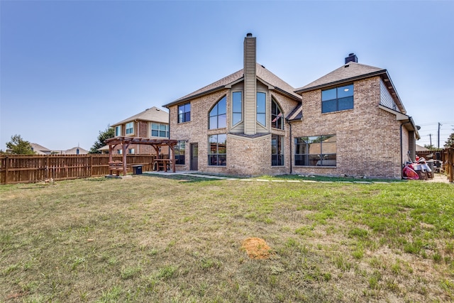 back of property featuring a pergola and a yard