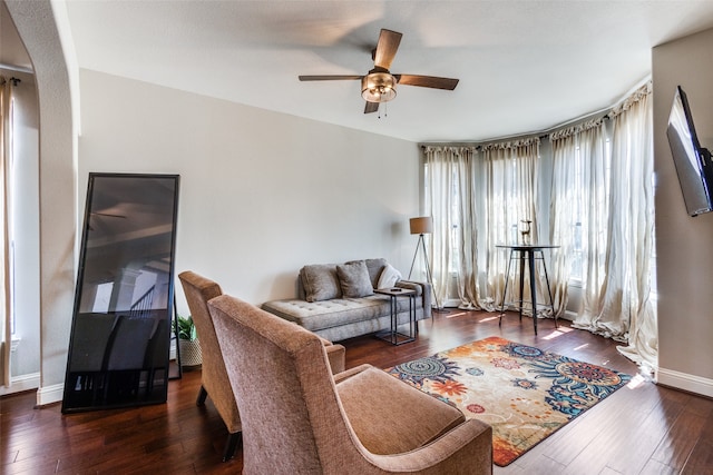 living room featuring dark wood-type flooring and ceiling fan