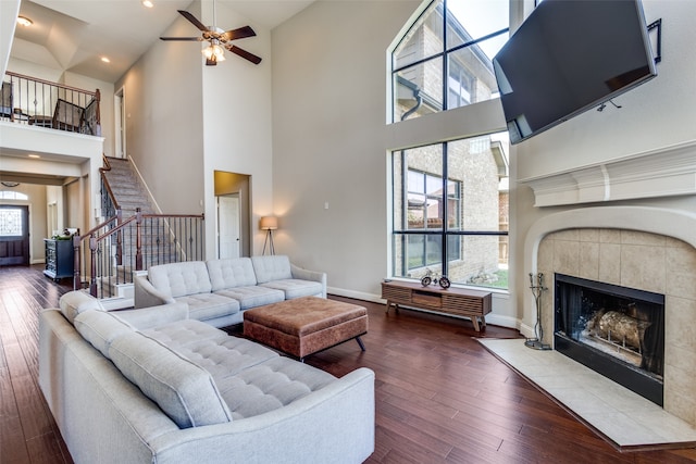 living room featuring a fireplace, high vaulted ceiling, wood-type flooring, and ceiling fan