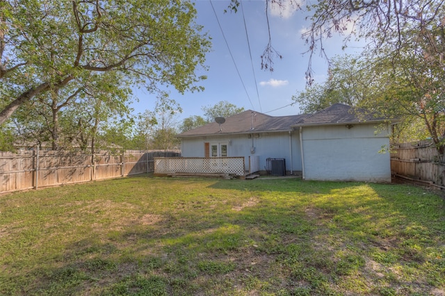 back of property with cooling unit and a yard