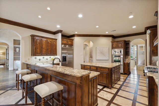 kitchen with a large fireplace, sink, appliances with stainless steel finishes, and a kitchen island