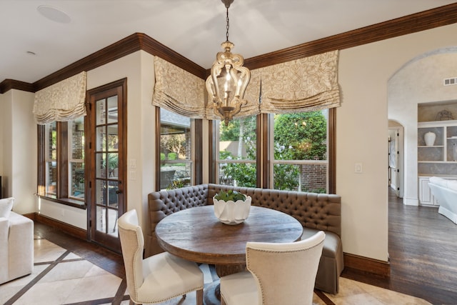 dining space featuring hardwood / wood-style flooring, a notable chandelier, and ornamental molding