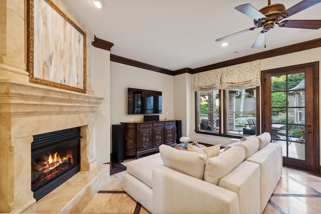 living room featuring ceiling fan, a healthy amount of sunlight, a high end fireplace, and ornamental molding