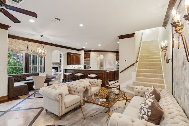 living room with crown molding and ceiling fan with notable chandelier