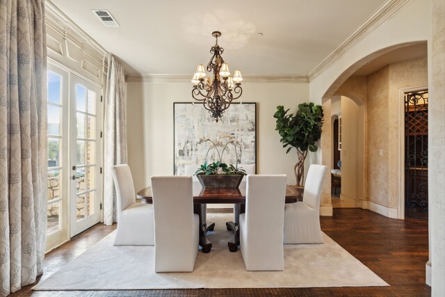 foyer entrance with a towering ceiling, ornamental molding, dark hardwood / wood-style floors, and a chandelier