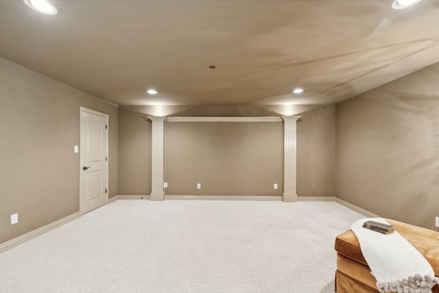 interior space featuring decorative columns and carpet floors