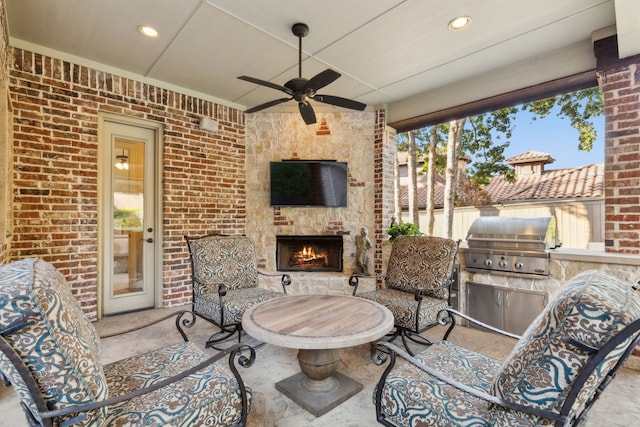 view of patio with ceiling fan, an outdoor kitchen, area for grilling, and an outdoor stone fireplace