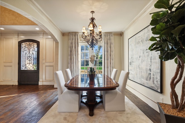 dining area featuring dark hardwood / wood-style flooring, crown molding, and a chandelier