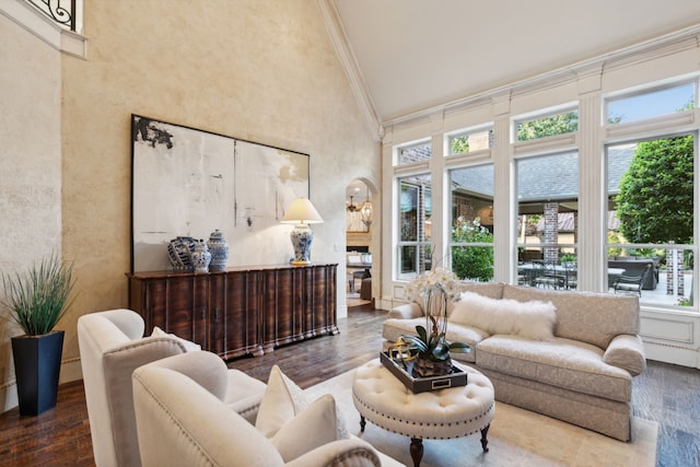 living room featuring a fireplace, crown molding, wood-type flooring, and high vaulted ceiling