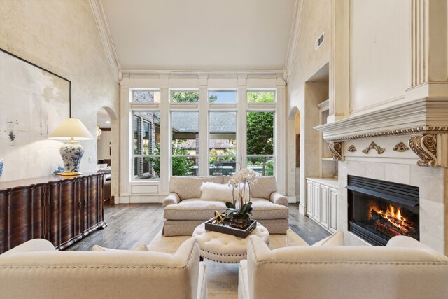 living room featuring built in features, hardwood / wood-style flooring, and a towering ceiling