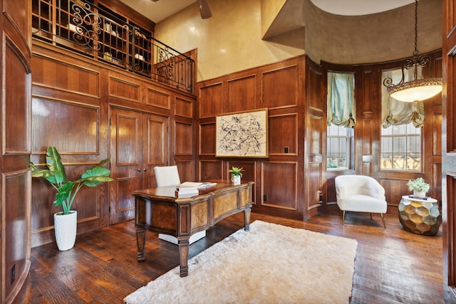 office featuring a towering ceiling and dark hardwood / wood-style flooring