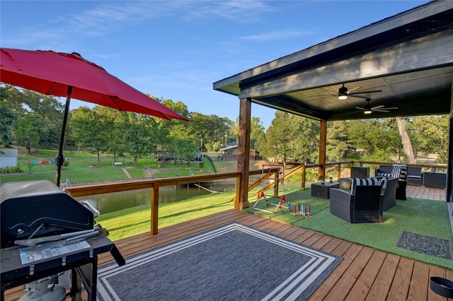 wooden deck featuring a water view, a lawn, ceiling fan, and outdoor lounge area