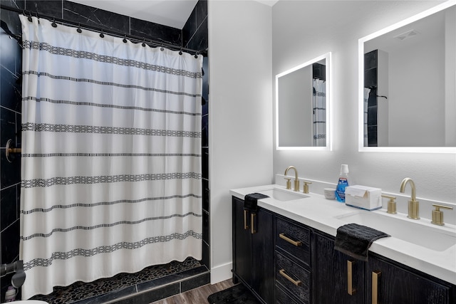 bathroom with a shower with shower curtain, hardwood / wood-style floors, and vanity