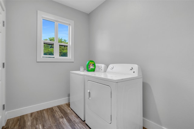 clothes washing area with wood-type flooring and washing machine and dryer