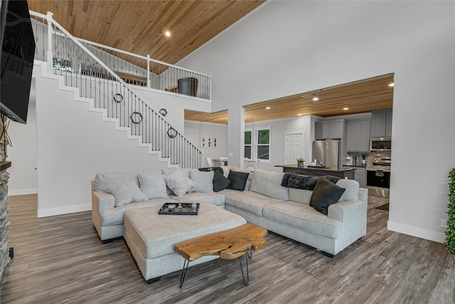 living room featuring wooden ceiling, hardwood / wood-style floors, and a high ceiling