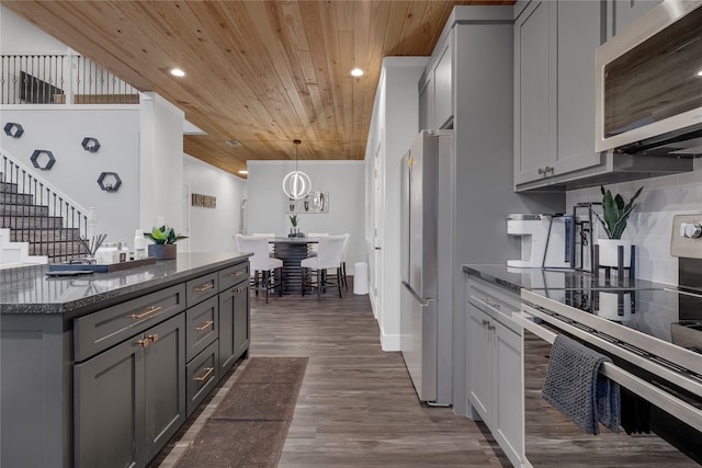 kitchen with hanging light fixtures, appliances with stainless steel finishes, wood ceiling, gray cabinets, and dark wood-type flooring