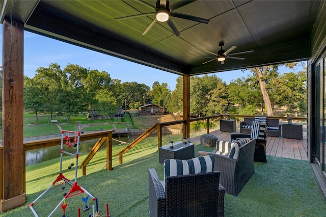 view of patio / terrace featuring a playground, ceiling fan, and a deck with water view