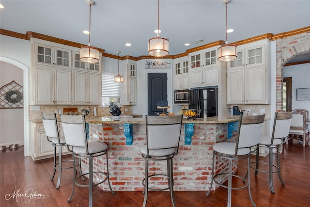 kitchen featuring decorative backsplash, crown molding, built in microwave, black refrigerator, and light stone counters