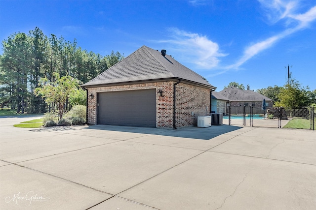 view of side of home with a garage and central AC