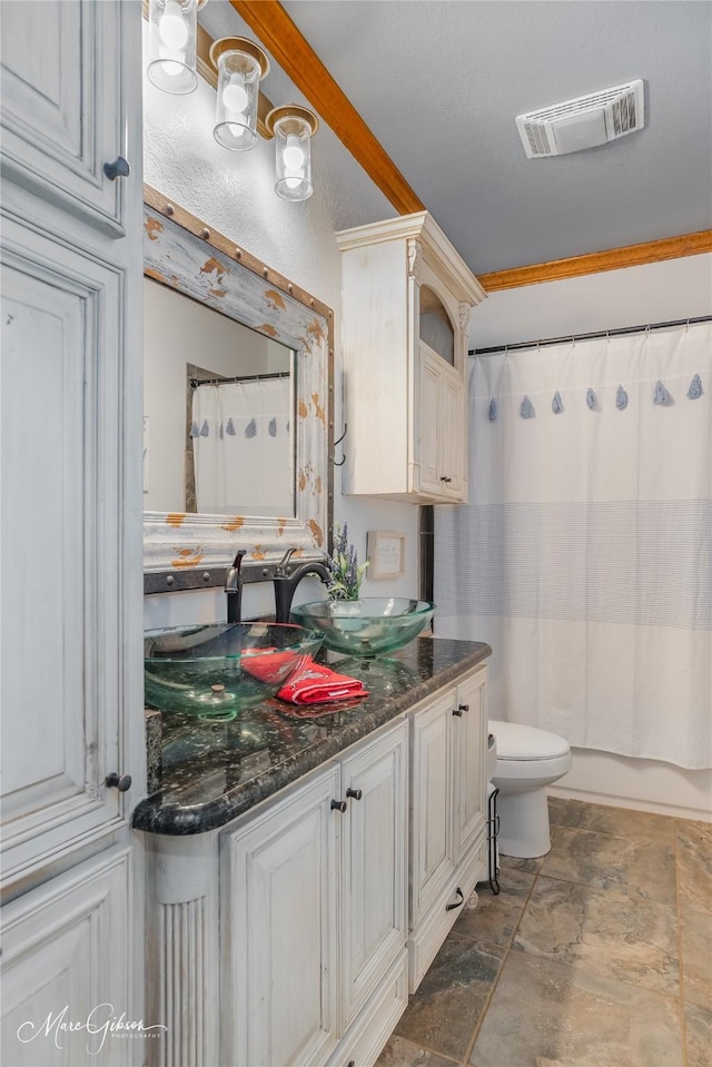 full bathroom with toilet, vanity, crown molding, and shower / tub combo with curtain