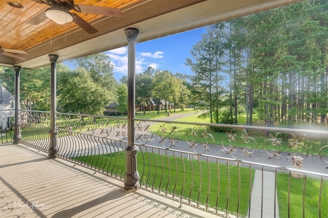 wooden deck with ceiling fan and a yard