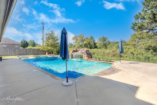 view of swimming pool featuring an in ground hot tub, pool water feature, and a patio