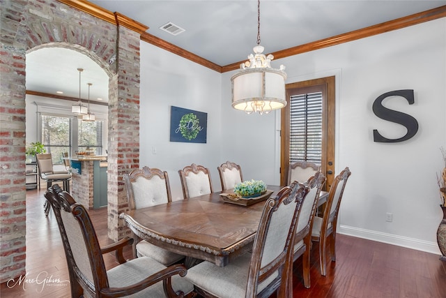 dining room featuring dark hardwood / wood-style floors, crown molding, and a healthy amount of sunlight