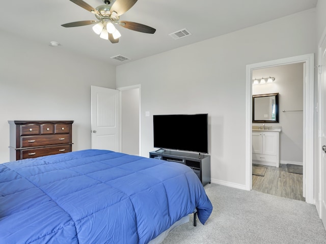 carpeted bedroom featuring ceiling fan, connected bathroom, and sink