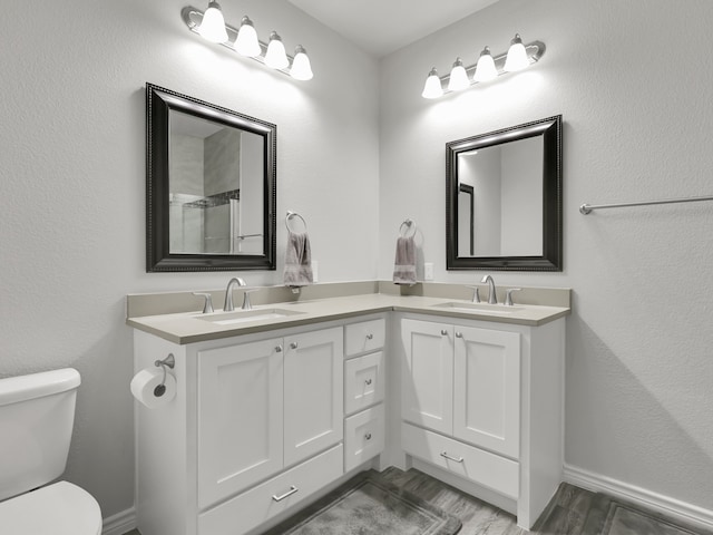 bathroom with vanity, toilet, and wood-type flooring