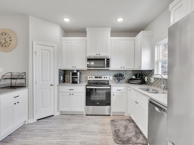 kitchen featuring light hardwood / wood-style flooring, stainless steel appliances, sink, and white cabinets