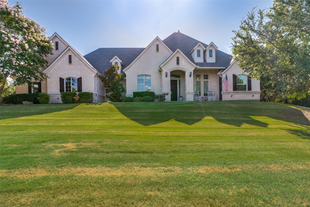 french country home featuring a front yard