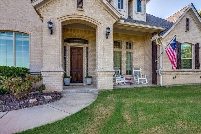 entrance to property featuring a lawn