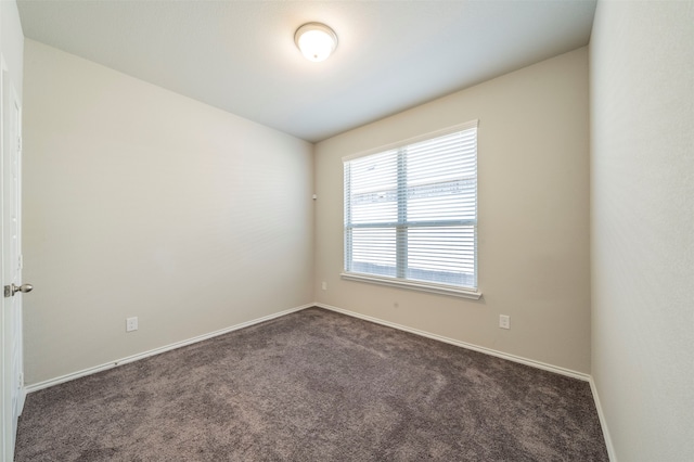 unfurnished room with dark colored carpet