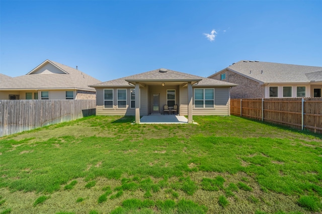 rear view of house featuring a patio area and a yard