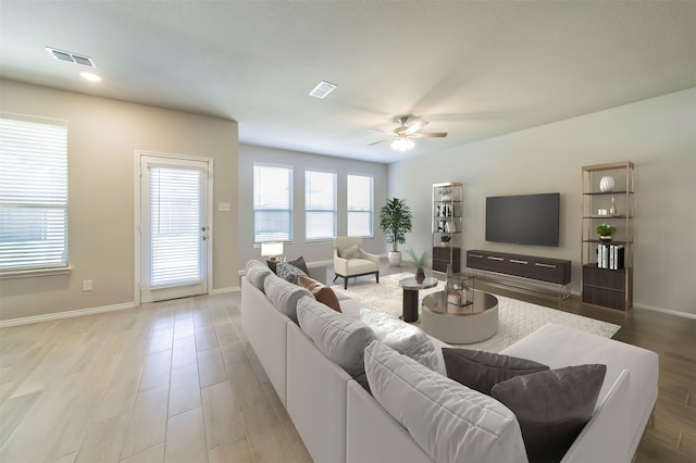 living room with light wood-type flooring and ceiling fan