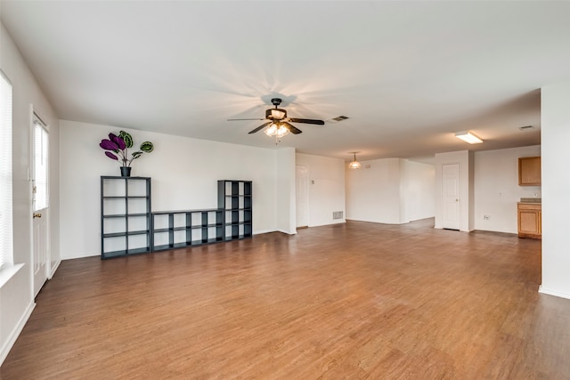 unfurnished living room with ceiling fan and wood-type flooring