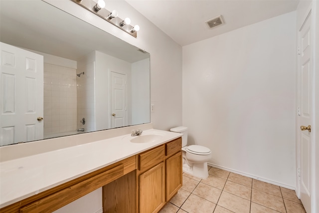 bathroom featuring vanity, toilet, tile patterned floors, and a tile shower