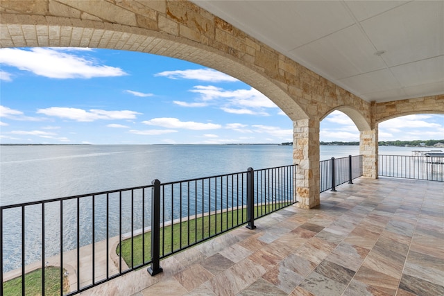 view of patio with a balcony and a water view