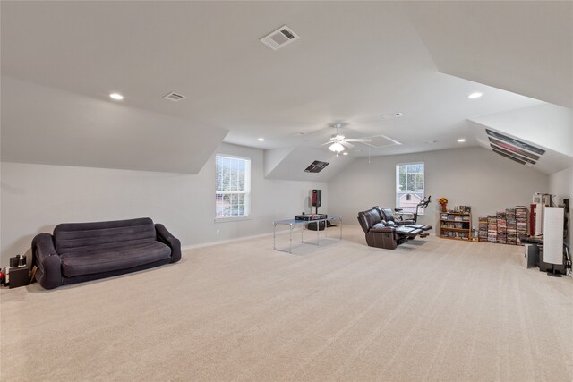 interior space with lofted ceiling, ceiling fan, light colored carpet, and a healthy amount of sunlight