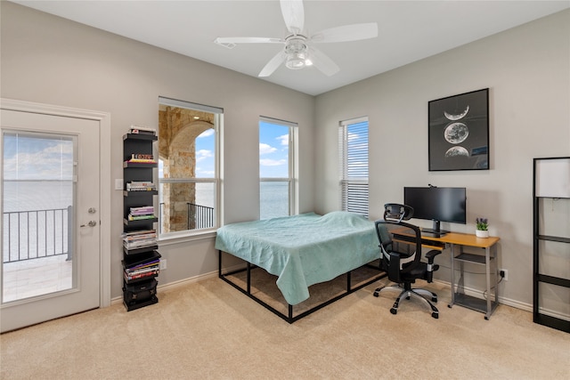 carpeted bedroom featuring ceiling fan and access to exterior