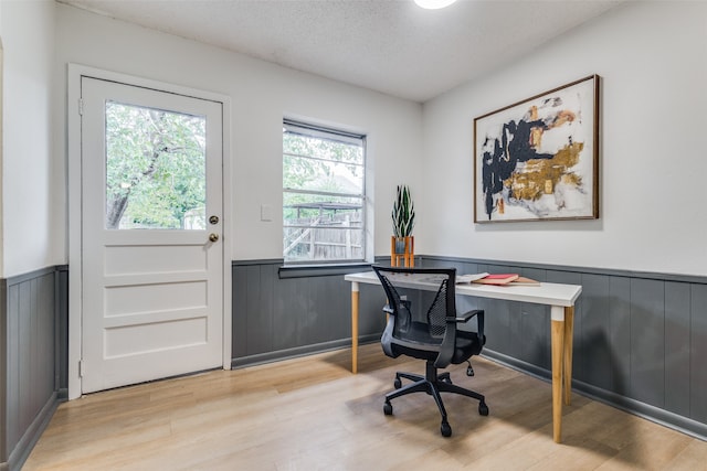 office area with a textured ceiling and light hardwood / wood-style floors