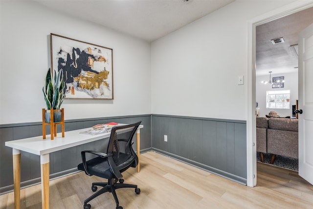 office with a textured ceiling, light hardwood / wood-style flooring, and a chandelier