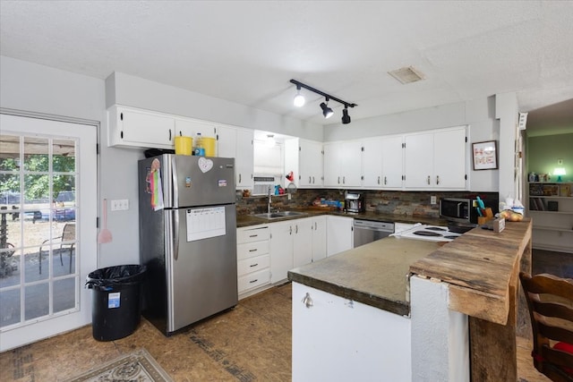 kitchen featuring decorative backsplash, white cabinets, appliances with stainless steel finishes, and sink