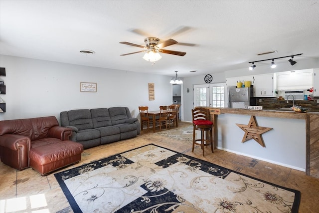 living room with ceiling fan, track lighting, and sink