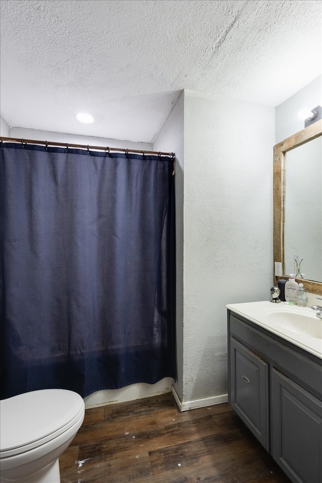 bathroom featuring hardwood / wood-style floors, vanity, toilet, and a textured ceiling