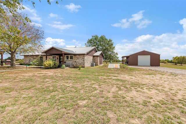 view of front of house with a garage, a front lawn, and an outdoor structure